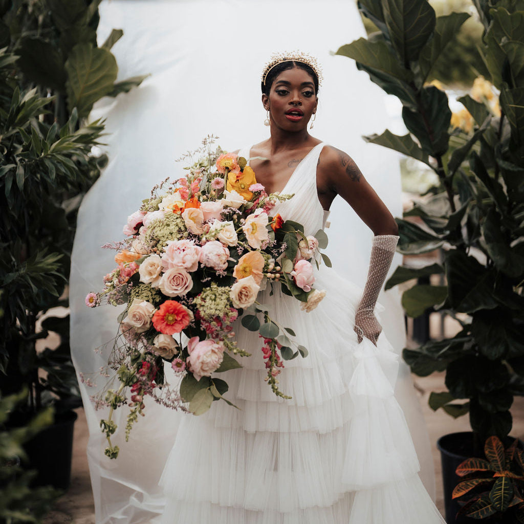 Bride holding a bouquet of flowers in a greenhouse setting